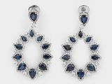 une paire de boucles d'oreilles en saphir et diamants sur fond blanc