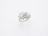 un gros plan d'une bague en or blanc sertie d'un diamant, sur fond blanc
