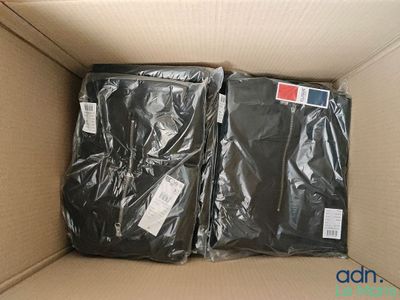 Deux sacs contenant des vêtements noirs se trouvent dans un carton