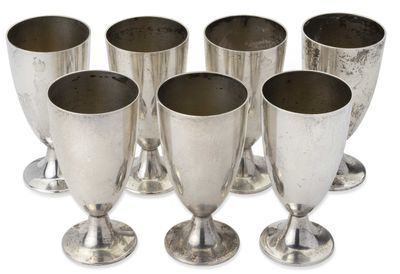 six gobelets en argent empilés les uns sur les autres sur une surface blanche