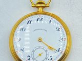 a close up of a gold pocket watch on a white surface