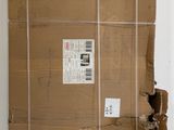 un grand carton posé par terre près d'un mur