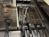 several fryers are lined up on a counter in a kitchen