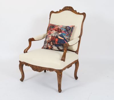 a white chair with a pillow on top of it in front of a white wall