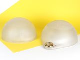 two plastic eggs sitting next to each other on a yellow and white surface