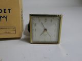 a clock that is sitting next to a box on a table