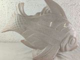 a white ceramic fish sculpture on a white table