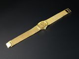 gros plan d'une montre en or sur une surface noire