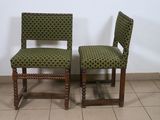 pair of green upholstered chairs on tiled floor with white wall