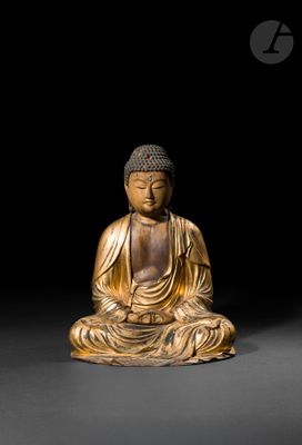 une statue en or représentant une personne assise en position de méditation