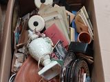une boîte en carton remplie d'objets divers, posée par terre