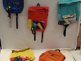 trois sacs à dos accrochés au mur les uns à côté des autres