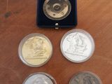 four different coins in a blue box on a wooden table