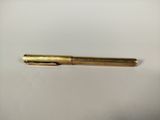 a gold pen sitting on top of a white surface