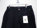 the black pants are hanging on a hanger on the wall