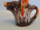 une tasse marron et orange ornée d'une tête d'animal