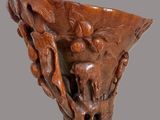 an image of a wooden vase with carvings of animals on it
