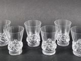 six shot glasses are lined up in a row on a table