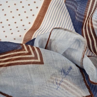 un gros plan sur une écharpe bleue et marron à pois