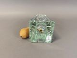 a small glass candle holder with a lemon on the table