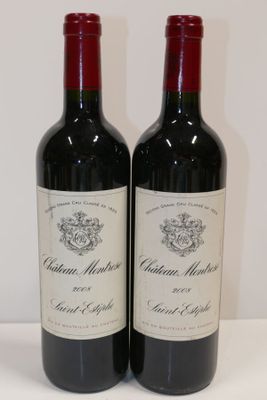 deux bouteilles de vin rouge posées sur une table blanche