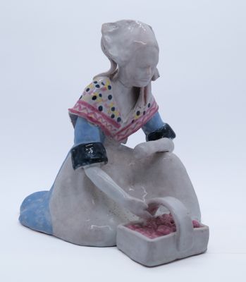 une figurine représentant une femme assise sur un rocher