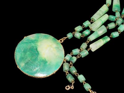 collier composé de perles vertes et d'un pendentif vert sur fond noir