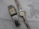 une montre en argent et un bracelet en argent posés sur une table en marbre