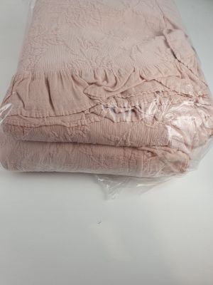 une pile de couvertures roses pliées sur une table blanche
