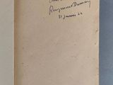 un livre ouvert, sur lequel est posée une note manuscrite, posé sur une table