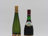 deux bouteilles de vin posées l'une à côté de l'autre sur une surface blanche