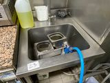 a sink in a kitchen with a blue hose next to it