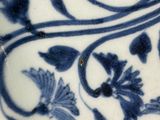 a close up of a blue and white plate with flowers on it