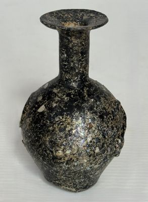un vase noir posé sur une surface blanche