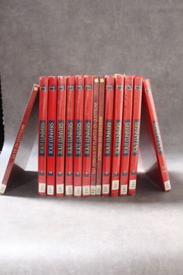 une pile de livres posée sur une table à côté d'une horloge