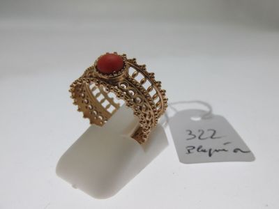 a close up of a gold ring with a red stone on it