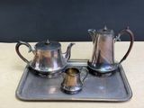 a silver tea set on a tray on a table