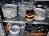 many plates and pans on the shelf in the kitchen