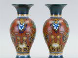 two vases sitting side by side on a white surface