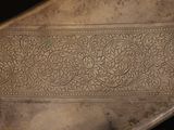 a close up of a metal plate with a design on it