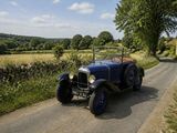 une voiture de collection roulant sur une route de campagne à la campagne