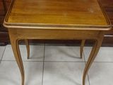 a small wooden table with a glass top on a tile floor