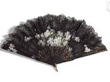 a black fan with white flowers on it on a white background