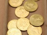 beaucoup de pièces d'or dans une boîte posée sur la table