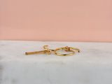 a close up of a pair of gold hoop earrings on a marble surface