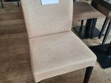 beige upholstered dining chair with a price tag on the back