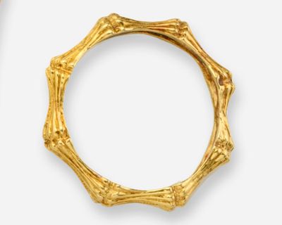 deux bijoux en or posés sur une surface blanche