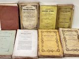 several old books sitting on top of each other on a table