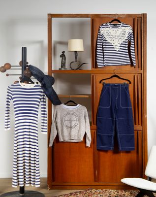 une armoire avec des vêtements et une chaise dans un coin