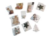 de nombreuses décorations de Noël dans des sachets, posées sur une surface blanche